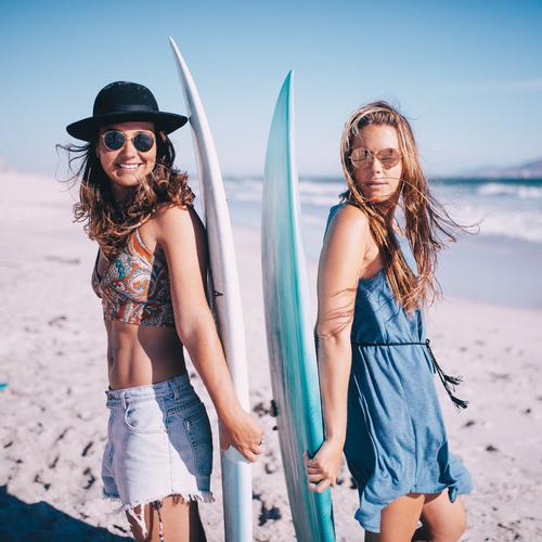 Portrait von zwei junge Frau mit Surfbrettern am Strand Lifestyle Freude Freizeit & Hobby Ferien & Urlaub & Reisen Sommer Sonnenbad Meer Sport Mensch feminin