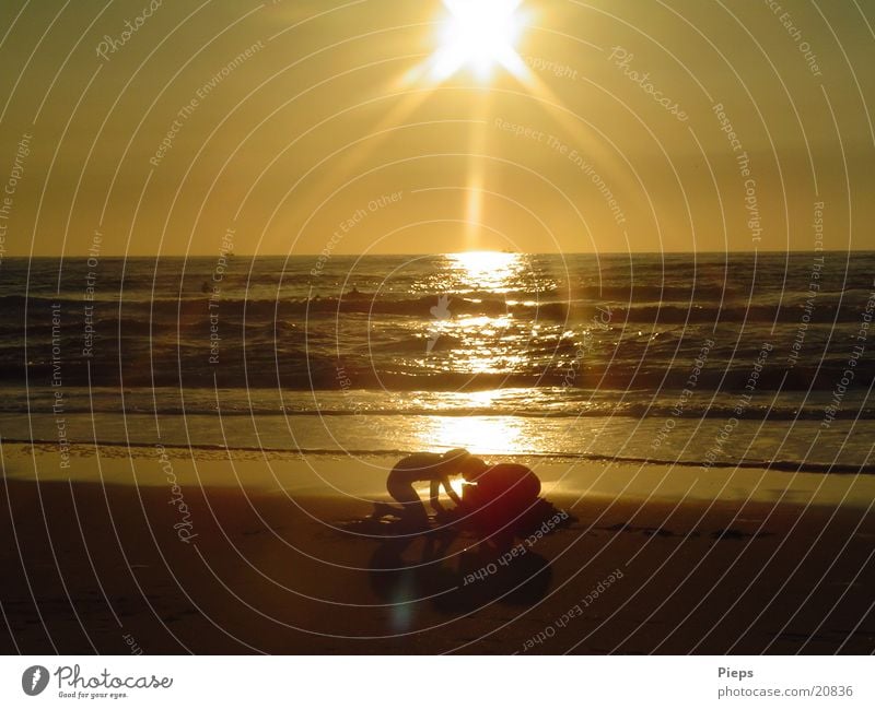 Goldgräberstimmung Farbfoto Außenaufnahme Abend Sonnenaufgang Sonnenuntergang Gegenlicht Freude Kinderspiel Sommer Strand Meer Geschwister Sand Wasser