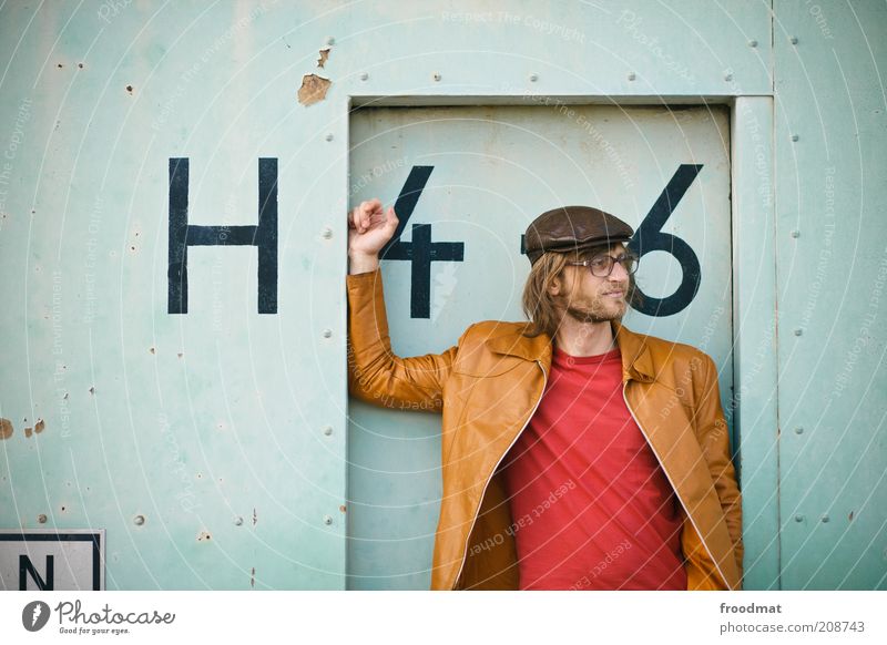 H46 Mensch maskulin Junger Mann Jugendliche Erwachsene Fassade Tür Mode Bekleidung T-Shirt Leder Mütze langhaarig Dreitagebart Vollbart Schriftzeichen