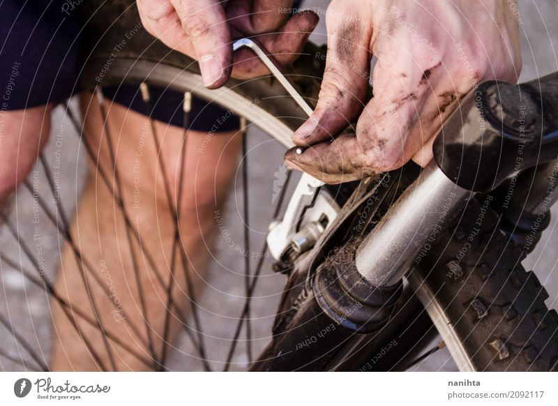 Junger Mann, der ein Fahrrad repariert Lifestyle Fahrradfahren Rad Sport Mensch maskulin Jugendliche Hand 1 18-30 Jahre Erwachsene berühren alt dreckig dunkel