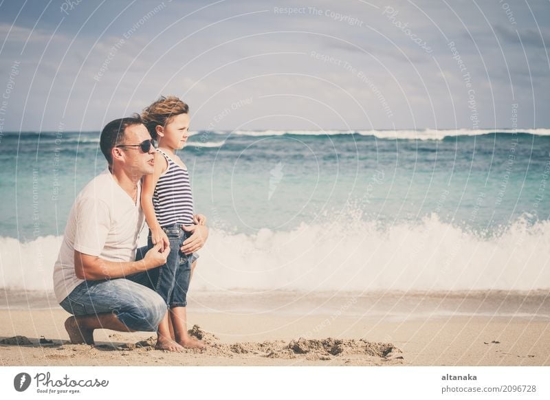 Glücklicher Vater und Sohn spielen am Strand in der Tageszeit. Konzept der freundlichen Familie. Lifestyle Freude Leben Erholung Freizeit & Hobby Spielen