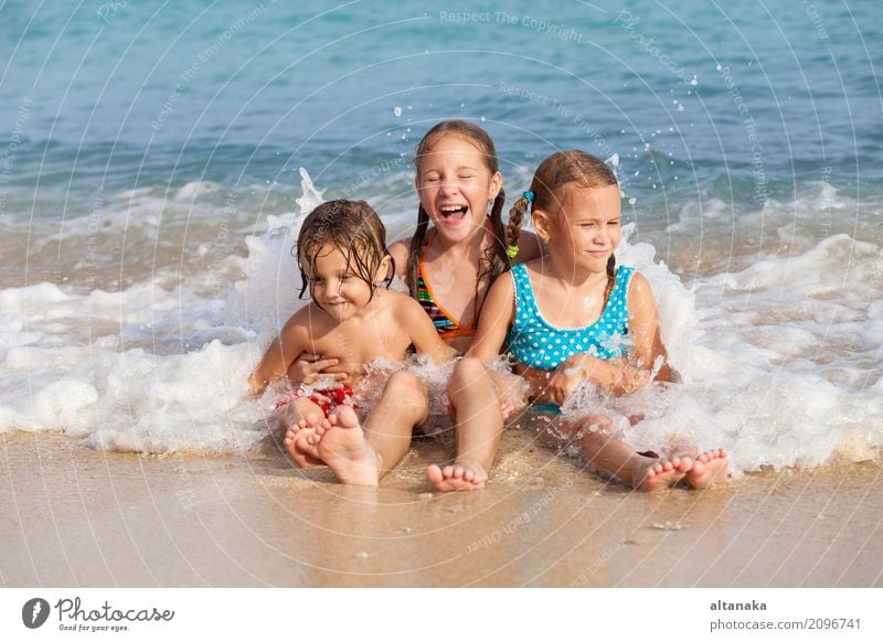 Zwei Schwestern und Bruder spielen am Strand am Tag. Konzept Bruder und Schwester zusammen für immer Lifestyle Freude Glück schön Erholung Freizeit & Hobby