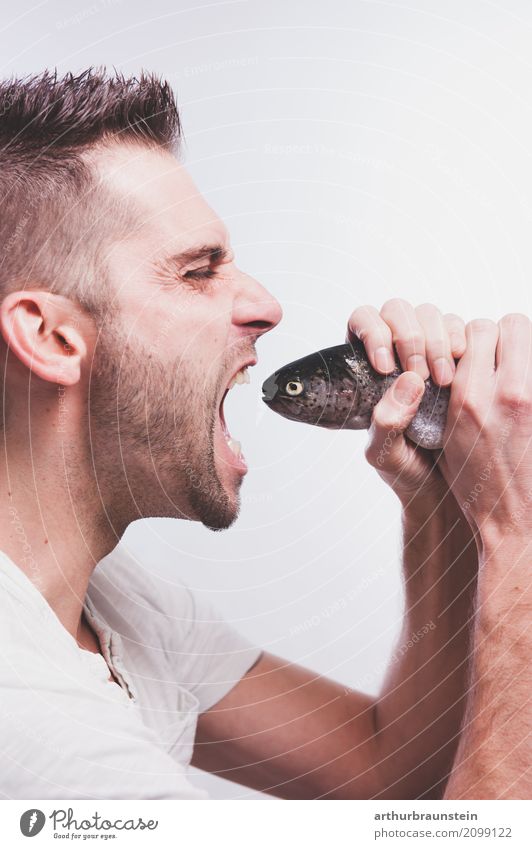Junger Mann isst frischen Fisch Lebensmittel Forelle Bachforelle Ernährung Essen Bioprodukte Slowfood kaufen Gesunde Ernährung Freizeit & Hobby Angeln Koch
