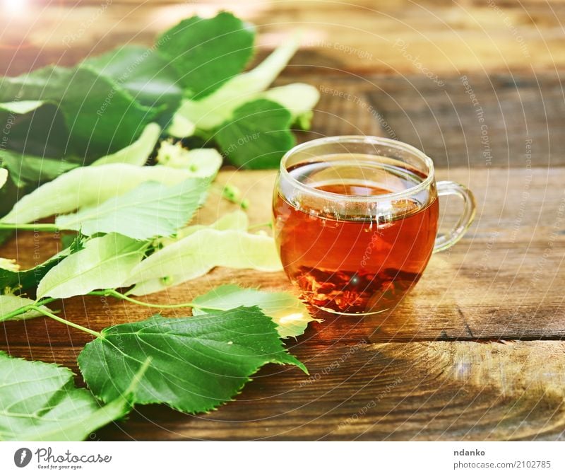 Kräutertee mit Linde Frühstück Heißgetränk Tee Tasse Becher Tisch Blatt Holz frisch heiß braun grün Kräuterbuch durchsichtig Ast trinken altehrwürdig nützlich