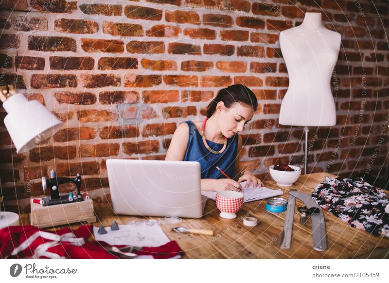 Junger weiblicher Modedesigner, der am Schreibtisch im Büro arbeitet lesen Arbeit & Erwerbstätigkeit Büroarbeit Business Mittelstand Technik & Technologie
