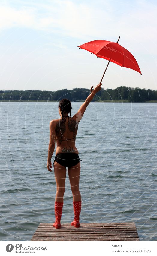 Hierher! Ferien & Urlaub & Reisen Tourismus Sommerurlaub Frau Erwachsene 1 Mensch Himmel Schönes Wetter See Menschenleer Bikini Gummistiefel Regenschirm