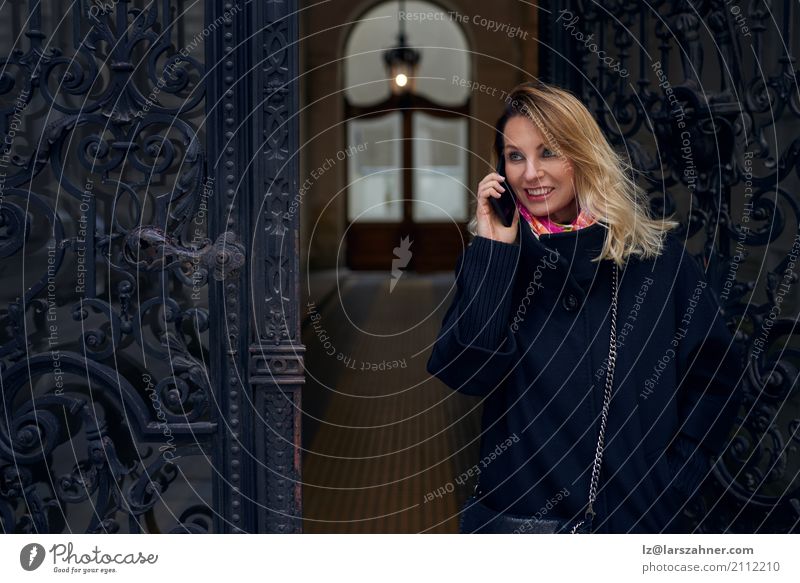 Frau, die in einer aufwändigen historischen Tür steht Stil Glück Winter Haus Business Telefon PDA Erwachsene 1 Mensch 30-45 Jahre Mantel blond hören