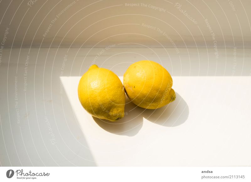Zwei Zitronen im Sonnenlicht auf einer Fensterbank Zitrusfrüchte Stillleben Licht Schatten Schattenspiel Kontrast Frucht Lebensmittel frisch Kunst natürlich