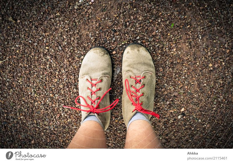 Zwei alte braune Schuhe mit roten Schnürsenkeln und jugendlichen Beinen von oben Fuß Erde authentisch unten Geborgenheit Verantwortung gewissenhaft Beginn Angst