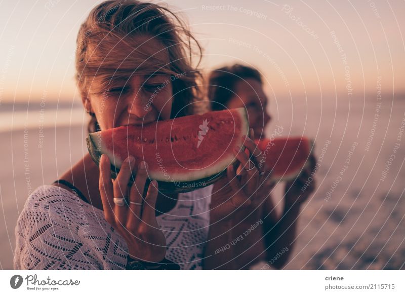 Frau, die Wassermelone am Strand im Sonnenuntergang isst Lebensmittel Frucht Essen Lifestyle Freude Glück Gesunde Ernährung Ferien & Urlaub & Reisen Sommer