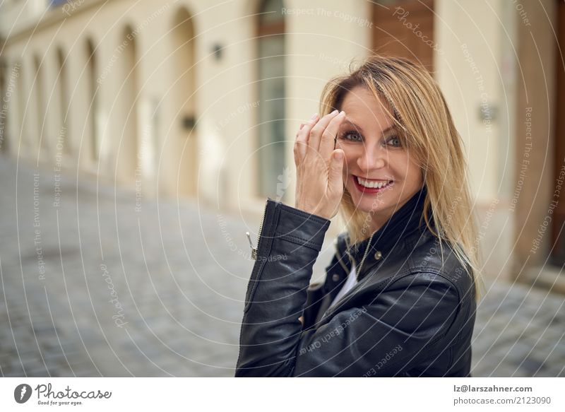 Attraktive Frau, die draußen in einem Hof ??steht Haut Gesicht Erwachsene 1 Mensch 30-45 Jahre Fußgänger Straße blond Lächeln historisch niedlich attraktiv