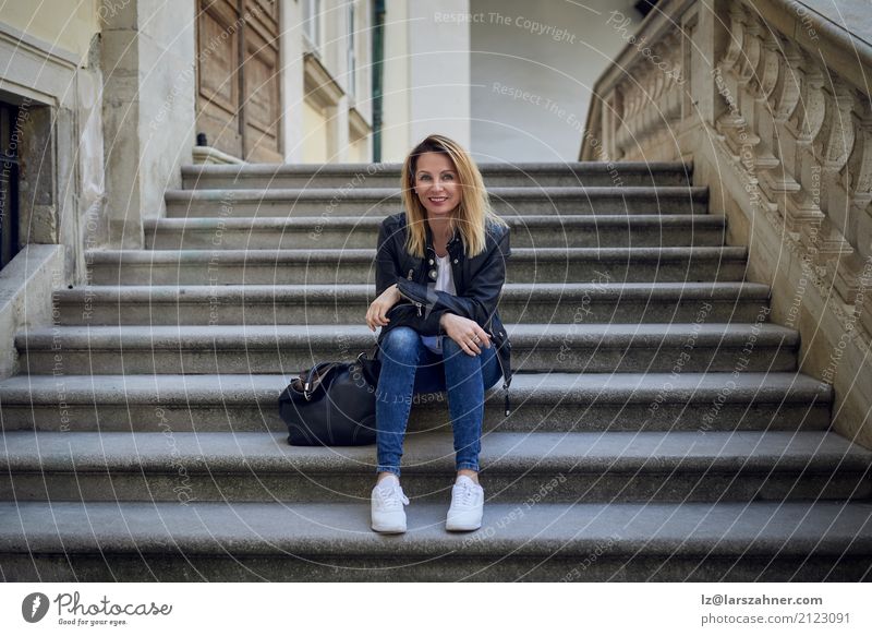 Junge lächelnde Frau, die auf Schritten sitzt 1 Mensch 30-45 Jahre Erwachsene Palast Treppe Lächeln sitzen warten dünn jung Freitreppe modisch attraktiv