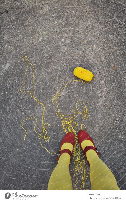 (zu)viel faden Schnur abgewickelt Wolle Wollknäuel Handarbeit drauf stehen füße Beine gelb rot Schuhe rote schuhe Asphalt Surrealismus