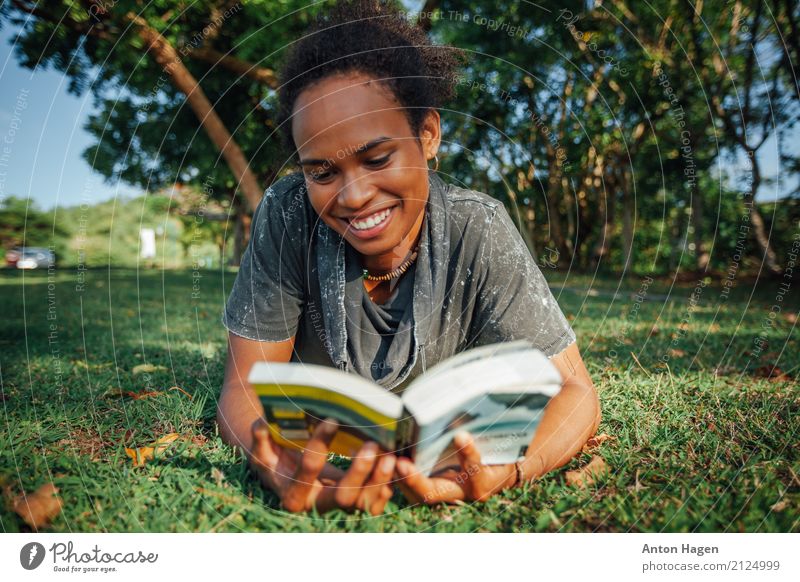 Buch der jungen Frau Leseim Park Junge Frau Jugendliche 1 Mensch 18-30 Jahre Erwachsene Blühend Lächeln lachen lernen lesen liegen Afro-Look Gras Afroamerikaner