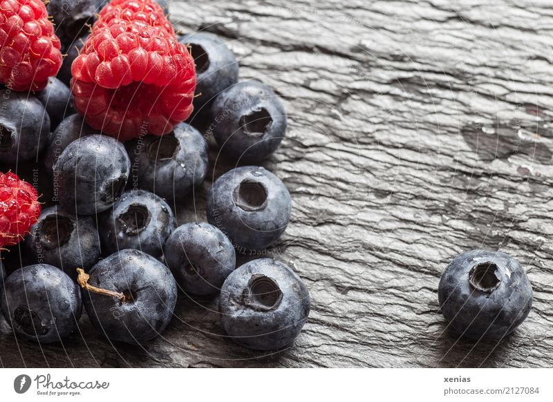 Blau- und Himbeeren auf Schieferplatte Frucht Blaubeeren Bioprodukte Vegetarische Ernährung Gesundheit Sommer Herbst Stein saftig süß blau rot schwarz Vitamin