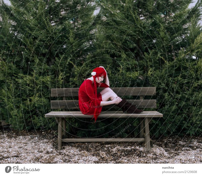 Junge Frau, die alleine in einer Holzbank sitzt Mensch feminin Jugendliche 1 18-30 Jahre Erwachsene Natur Baum Park Kleid Stiefel rothaarig Perücke Zopf Bank