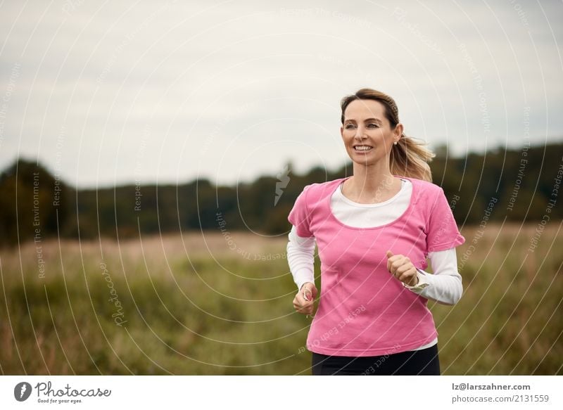 Nette Frau, die durch Feld läuft Lifestyle Gesicht Sommer Sport Joggen Erwachsene 1 Mensch 30-45 Jahre Natur Herbst blond Fitness Lächeln heiter rennen