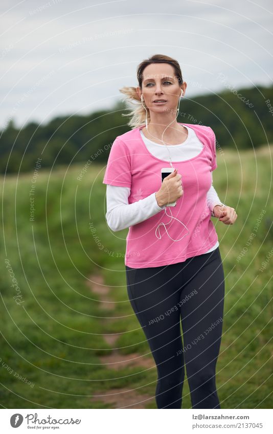 Starke Frau, die durch Feld läuft Lifestyle Gesicht Sommer Musik Sport Joggen PDA Erwachsene 1 Mensch 30-45 Jahre Natur Herbst blond Fitness hören rennen