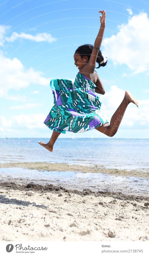 in | Feierlaune | über den Strand schweben feminin Mädchen 1 Mensch Sand Küste Ostsee Kleid schwarzhaarig langhaarig fliegen springen schön Freude Lebensfreude