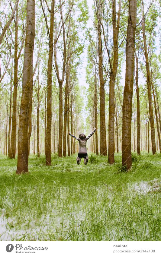 Junge Frau, die mitten in einem Wald springt Wellness Leben Ferien & Urlaub & Reisen Abenteuer Ferne Freiheit Expedition Mensch feminin Jugendliche 1