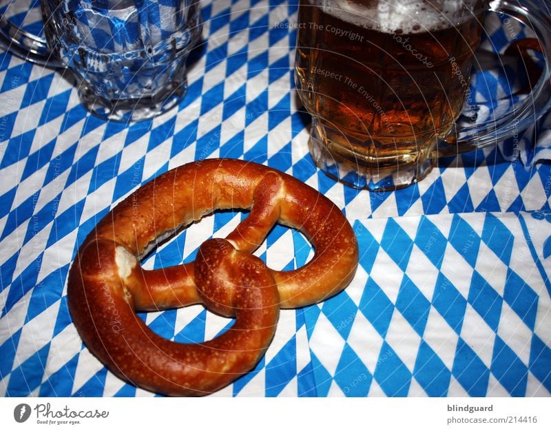 Oktober fest in bayerischer Hand Lebensmittel Getränk Bier Glas Nachtleben Oktoberfest trinken blau weiß Bayern Brezel Muster Schaum Laugengebäck Alkohol