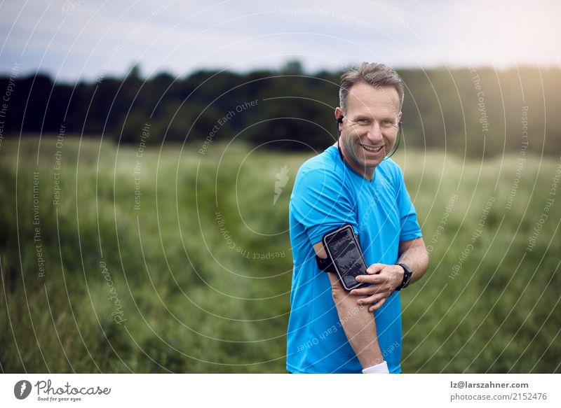 Mann mit Smartphone auf seinem Arm, der in der Wiese steht Gesicht Sommer Sport PDA Technik & Technologie Erwachsene Arme 1 Mensch 30-45 Jahre Landschaft Wald