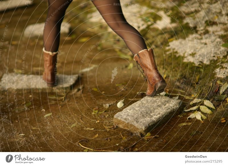 mit großen Schritten Mensch feminin Umwelt Natur Park Bekleidung Strumpfhose Leder Stiefel Stein laufen Stimmung kalt robust Boden Erde dreckig Farbfoto