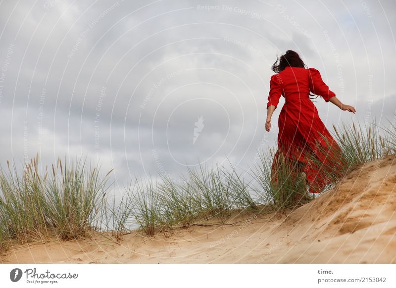 Frau im roten Kleid auf einer Düne feminin Erwachsene 1 Mensch Sand Wolken Gewitterwolken Wind Sturm Dünengras brünett langhaarig Bewegung laufen Gefühle