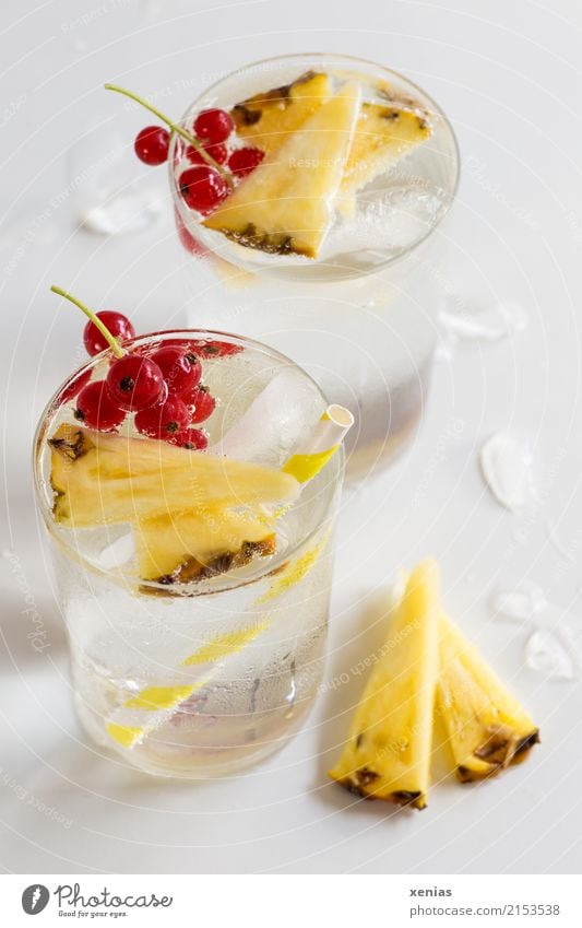 Aromawasser mit Ananas und roter Johannisbeere Frucht Johannisbeeren Eiswürfel Getränk Erfrischungsgetränk Trinkwasser Limonade Glas Trinkhalm Gesunde Ernährung