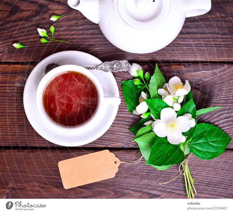 heißer schwarzer Tee in einer weißen Tasse Frühstück Getränk Löffel Tisch Blume Blatt Holz frisch oben retro braun grün Tradition Jasmin trinken Lebensmittel