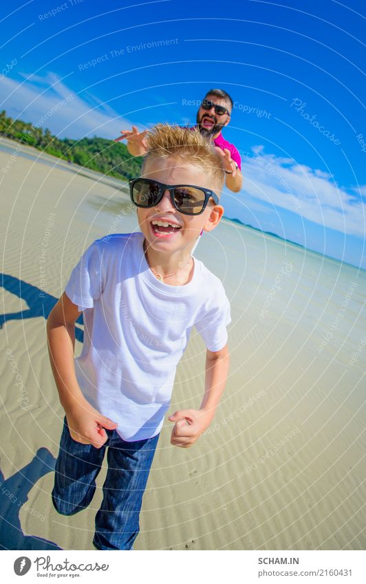 Die glücklichste Kindheit: Vater und Sohn laufen am tropischen Strand entlang. Beide in legerer Kleidung und mit Sonnenbrille Freude Sommer Insel maskulin Junge