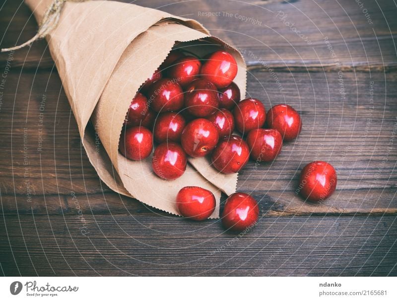rote Kirsche in einer Papiertüte Frucht Dessert Essen Vegetarische Ernährung Saft Sommer Garten Tisch Holz frisch natürlich retro saftig braun Hintergrund