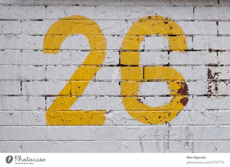 26 Bauwerk Mauer Wand Backstein Ziffern & Zahlen gelb weiß Farbstoff Anstrich abblättern Furche Farbfoto Außenaufnahme Strukturen & Formen Menschenleer