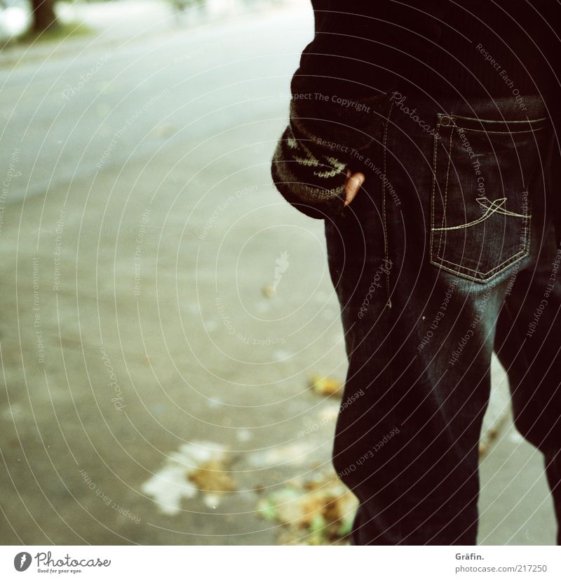 [HH 10.1] Waiting Mensch Mann Erwachsene Herbst Blatt Straße Jeanshose Handschuhe stehen warten kalt grau schwarz geduldig Einsamkeit Asphalt analog