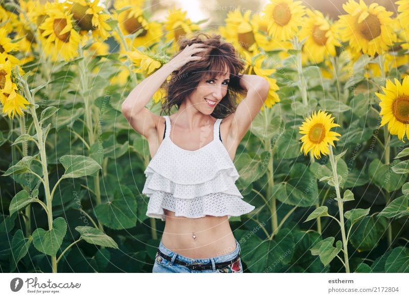 lächelndes Mädchen im Sonnenblumenfeld Lifestyle Freude Wellness Leben Zufriedenheit Mensch feminin Junge Frau Jugendliche Erwachsene 1 30-45 Jahre Pflanze Feld