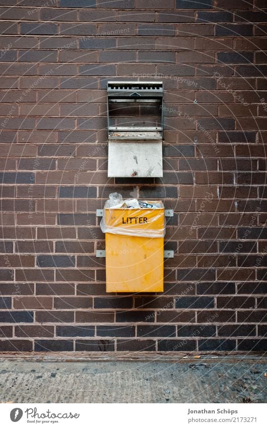 englischer Mülleimer an einer Wand Stadt Stadtzentrum dreckig gelb Müllbehälter Müllmann Müllabfuhr Müllverwertung Müllentsorgung Backstein England Englisch