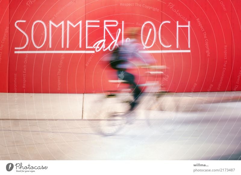 Radfahrer fährt schnell durch das Sommerloch Fahrradfahrer Fahrradfahren Geschwindigkeit Langzeitbelichtung Freizeit Wand Schriftzeichen und Buchstaben Text