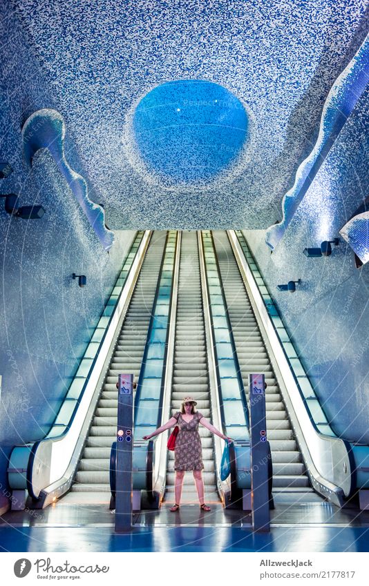 Frau steht or einer Rolltreppe in der U-Bahnstation feminin Hut Kleid Kunstlicht Untergrund Treppe Fliesen u. Kacheln Futurismus Unterwasseraufnahme