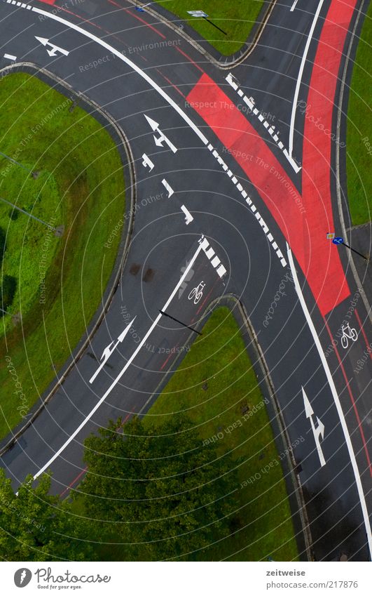 geregelt Menschenleer Verkehr Verkehrswege Straßenverkehr Straßenkreuzung Verkehrszeichen Verkehrsschild grau grün rot Fahrradweg Pfeil Spurwechsel Wiese