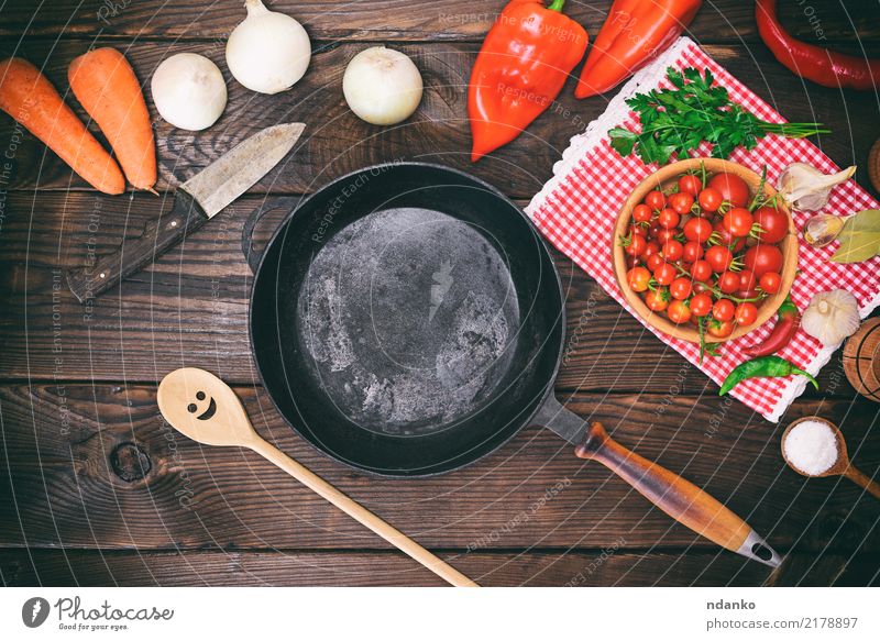 leere schwarze runde Bratpfanne Gemüse Ernährung Essen Pfanne Löffel Küche Holz braun Gußeisen Tomate Zwiebel Salz Messer reif Koch Zutaten Salat nützlich