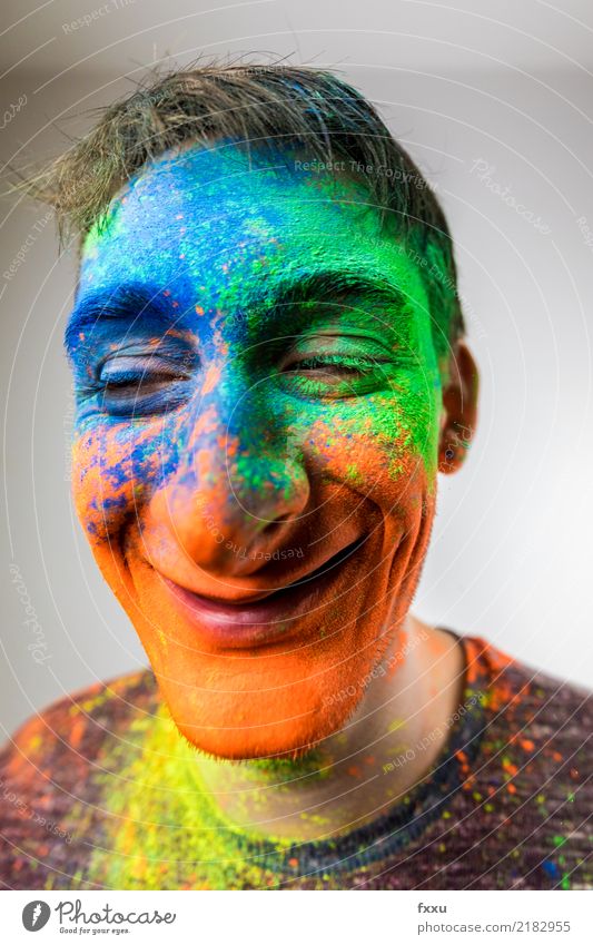 Mann mit Holi Pulver im Gesicht karikatur mehrfarbig lachen Lächeln verrückt Perspektive Holi Kino Junger Mann blau gelb grün orange Nase groß