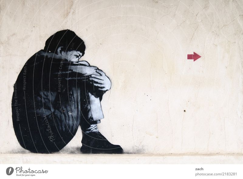 richtungsweisend Mensch Frau Erwachsene Mauer Wand Fassade Schilder & Markierungen Graffiti Pfeil sitzen Traurigkeit grau Trauer Müdigkeit Enttäuschung