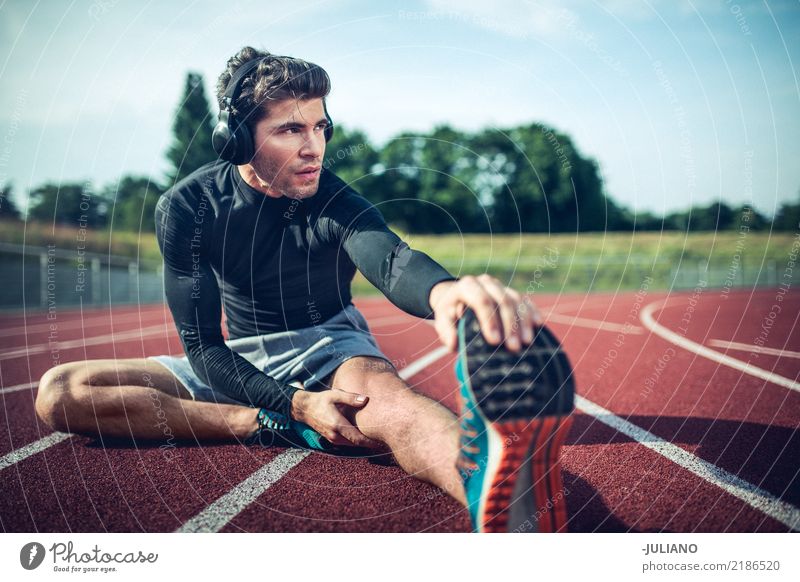Junger Läufer dehnt vor Training aus Ernährung Lifestyle Gesundheit sportlich Fitness Freizeit & Hobby Sport Sport-Training Leichtathletik Sportler Erfolg