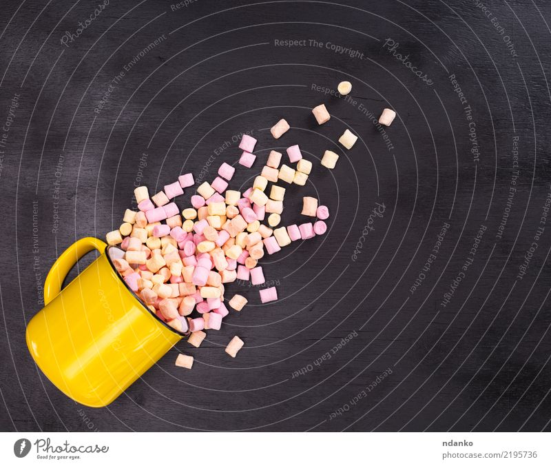 Stücke von farbigen Marshmallows Dessert Süßwaren Tasse Becher Tisch Holz Essen lecker weich gelb rosa schwarz weiß Hintergrund farbenfroh Bonbon Pastell