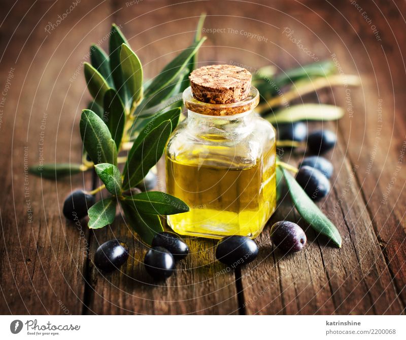 Olivenöl und frische Oliven auf rustikalem hölzernem Hintergrund Gemüse Ernährung Diät Flasche Blatt dunkel natürlich retro braun gelb grün Ast Komparse