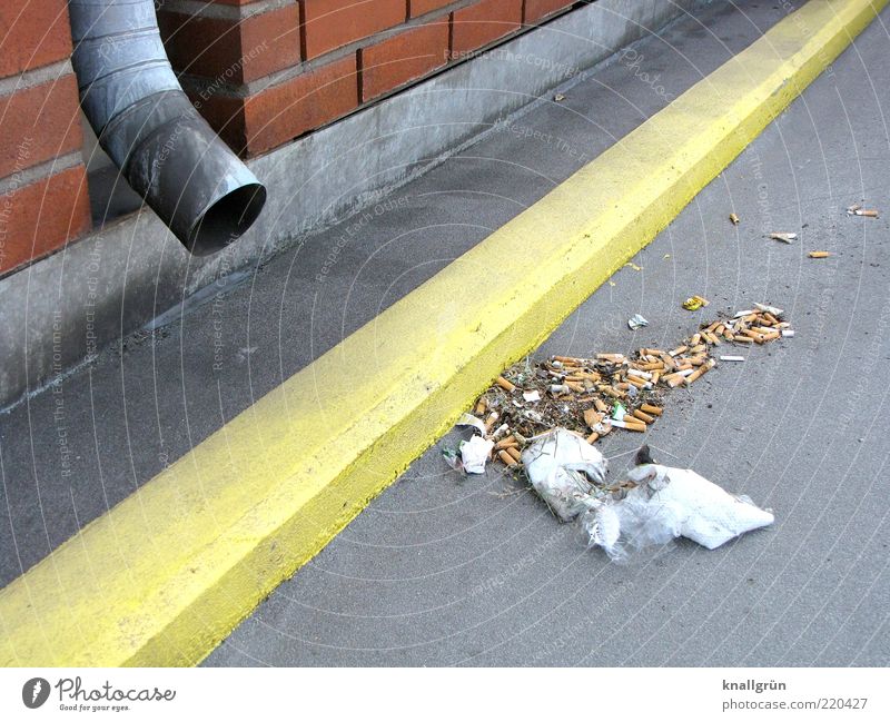 Hinterlassenschaften Mauer Wand Abflussrohr dreckig gelb grau Umweltverschmutzung Müll Fahrbahnmarkierung Farbfoto Außenaufnahme Menschenleer Tag