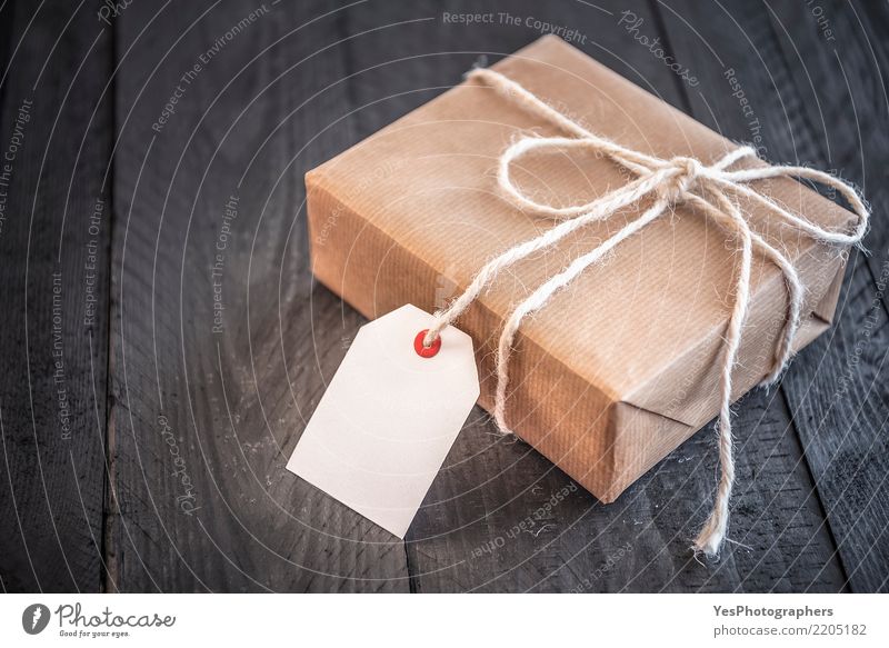 Papier eingewickeltes Geschenk mit leerer Marke Feste & Feiern Silvester u. Neujahr Geburtstag Handwerk Paket Schnur Überraschung schwarzer Hintergrund