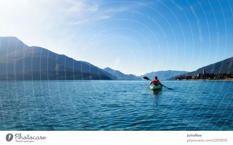 Paddeln am Comer See Provinz Como di como Italien Wasser ruhig Wasserfahrzeug Kanu fahren kanu fahren boot fahren Mensch allein Berge u. Gebirge blau