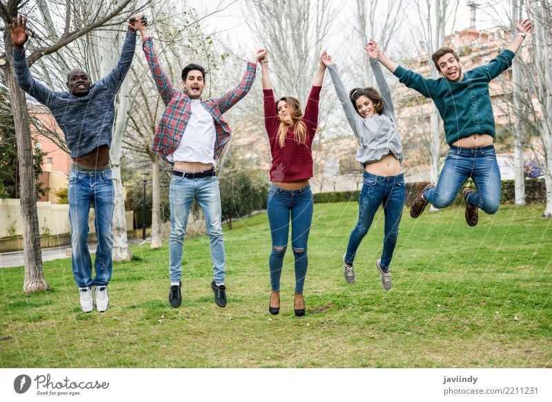 Eine Gruppe multiethnischer Jugendlicher springt zusammen Lifestyle Freude Mensch Frau Erwachsene Mann Freundschaft 5 Menschengruppe 18-30 Jahre Park Straße