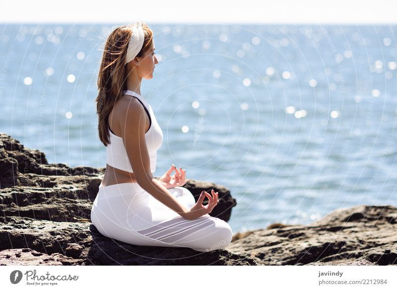 Junge Frau macht Yoga am Strand. Frau trägt weiße Sportkleidung in Lotusfigur Lifestyle schön Wellness Erholung Meditation Sommer Meer Mensch Erwachsene 1